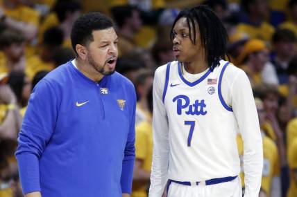 Jan 9, 2024; Pittsburgh, Pennsylvania, USA;  Pittsburgh Panthers head coach Jeff Capel (left) talks with guard Carlton Carrington (7) against the Duke Blue Devils during the first half at the Petersen Events Center. Mandatory Credit: Charles LeClaire-USA TODAY Sports