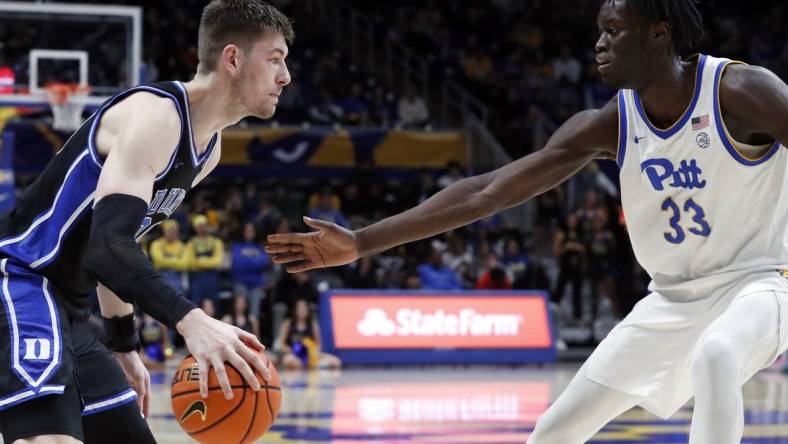 Jan 9, 2024; Pittsburgh, Pennsylvania, USA;  Duke Blue Devils center Kyle Filipowski (30) drives to the basket against Pittsburgh Panthers center Federiko Federiko (33) during the second half at the Petersen Events Center. Duke won 75-53. Mandatory Credit: Charles LeClaire-USA TODAY Sports