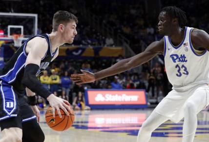 Jan 9, 2024; Pittsburgh, Pennsylvania, USA;  Duke Blue Devils center Kyle Filipowski (30) drives to the basket against Pittsburgh Panthers center Federiko Federiko (33) during the second half at the Petersen Events Center. Duke won 75-53. Mandatory Credit: Charles LeClaire-USA TODAY Sports
