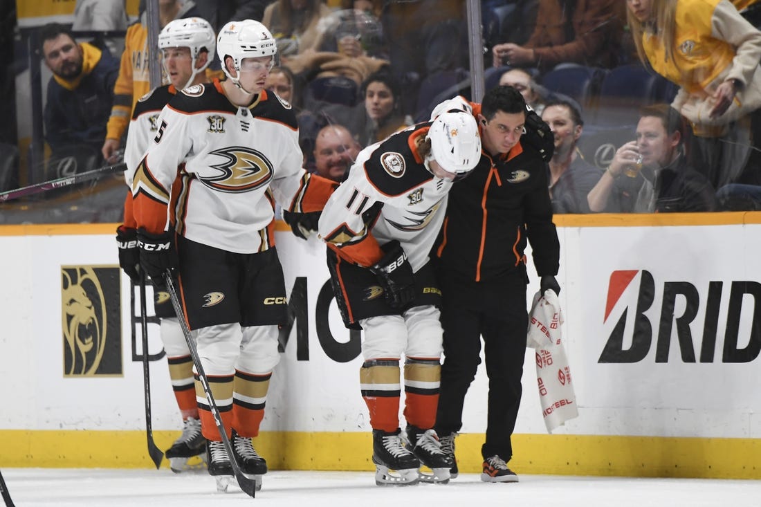 Jan 9, 2024; Nashville, Tennessee, USA; Anaheim Ducks center Trevor Zegras (11) is helped off the ice after an injury first period against the Nashville Predators at Bridgestone Arena. Mandatory Credit: Christopher Hanewinckel-USA TODAY Sports