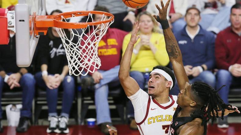 Iowa State Cyclones guard Tamin Lipsey (3) lays up the ball around Houston Cougars forward Joseph Tugler (25) during the second half in the Big-12 conference showdown of an NCAA college basketball at Hilton Coliseum on Tuesday, Jan. 9, 2024, in Ames, Iowa.