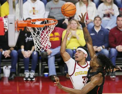 Iowa State Cyclones guard Tamin Lipsey (3) lays up the ball around Houston Cougars forward Joseph Tugler (25) during the second half in the Big-12 conference showdown of an NCAA college basketball at Hilton Coliseum on Tuesday, Jan. 9, 2024, in Ames, Iowa.