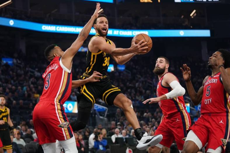 Jan 10, 2024; San Francisco, California, USA; Golden State Warriors guard Stephen Curry (30) attempts a shot next to New Orleans Pelicans guard CJ McCollum (3) in the first quarter at the Chase Center. Mandatory Credit: Cary Edmondson-USA TODAY Sports