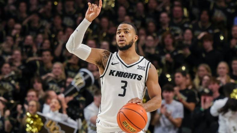 Jan 10, 2024; Orlando, Florida, USA; UCF Knights guard Darius Johnson (3) signals to teammates as he brings the ball up court during the second half against the Kansas Jayhawks at Addition Financial Arena. Mandatory Credit: Mike Watters-USA TODAY Sports