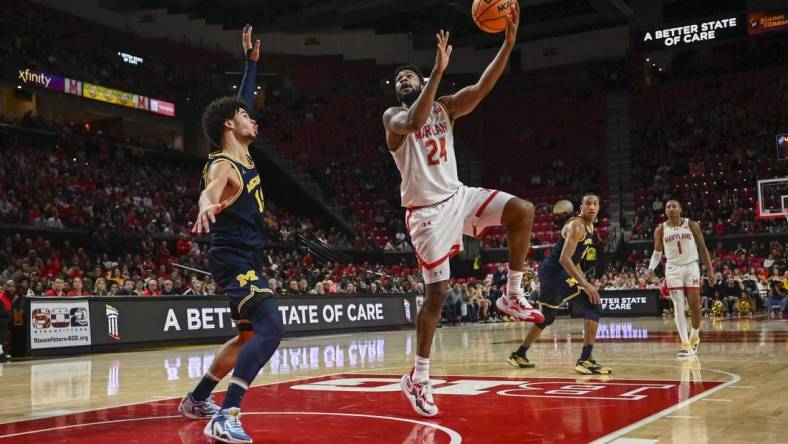 Jan 11, 2024; College Park, Maryland, USA;  
Maryland Terrapins forward Donta Scott (24) shoots a sky hook over Michigan Wolverines forward Olivier Nkamhoua (13) during the second half at Xfinity Center. Mandatory Credit: Tommy Gilligan-USA TODAY Sports