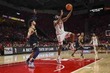 Jan 11, 2024; College Park, Maryland, USA;  
Maryland Terrapins forward Donta Scott (24) shoots a sky hook over Michigan Wolverines forward Olivier Nkamhoua (13) during the second half at Xfinity Center. Mandatory Credit: Tommy Gilligan-USA TODAY Sports