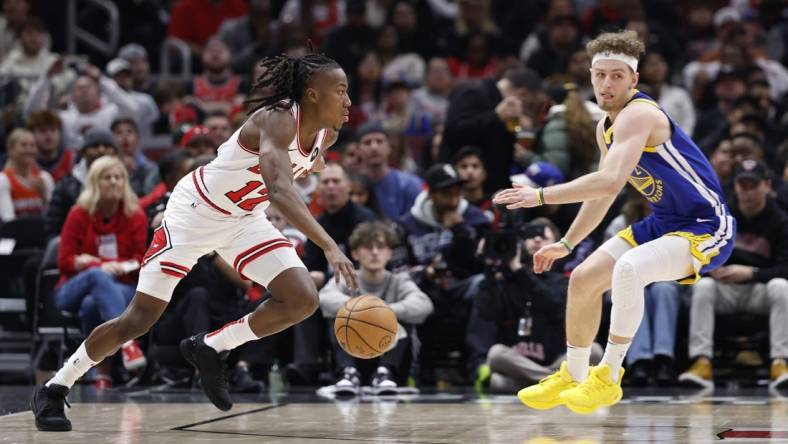 Jan 12, 2024; Chicago, Illinois, USA; Chicago Bulls guard Ayo Dosunmu (12) drives against Golden State Warriors guard Brandin Podziemski (2) during the first half at United Center. Mandatory Credit: Kamil Krzaczynski-USA TODAY Sports