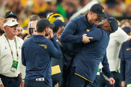 Michigan head coach Jim Harbaugh is lifted off the ground by offensive coordinator Sherrone Moore after Michigan won the College Football Playoff national championship game against Washington at NRG Stadium in Houston on Monday, Jan. 8, 2024.