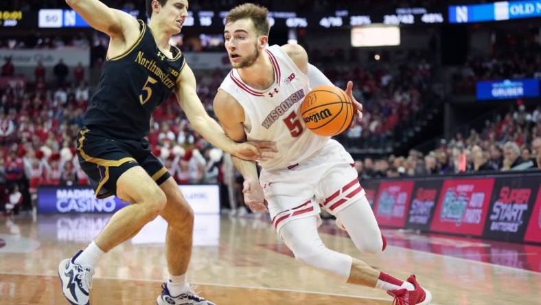 Jan 13, 2024; Madison, Wisconsin, USA; Wisconsin Badgers forward Tyler Wahl (5) dribbles the ball against Northwestern Wildcats guard Ryan Langborg (5) during the second half at the Kohl Center. Mandatory Credit: Kayla Wolf-USA TODAY Sports