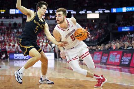 Jan 13, 2024; Madison, Wisconsin, USA; Wisconsin Badgers forward Tyler Wahl (5) dribbles the ball against Northwestern Wildcats guard Ryan Langborg (5) during the second half at the Kohl Center. Mandatory Credit: Kayla Wolf-USA TODAY Sports