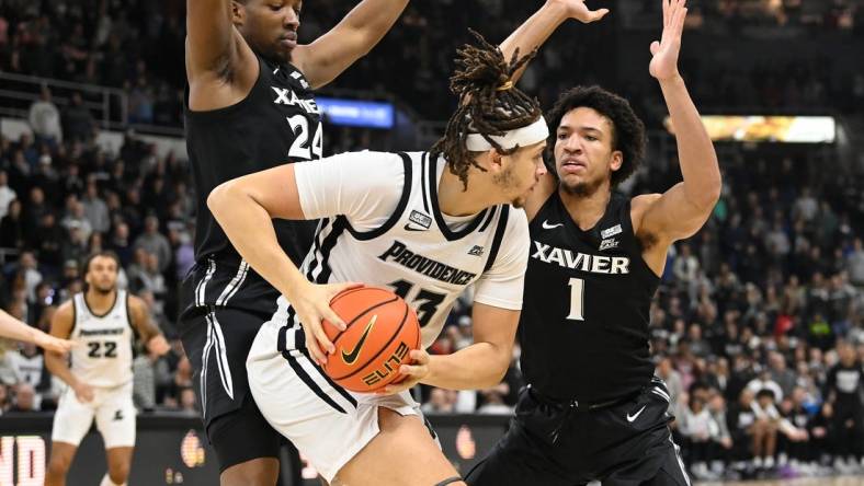 Jan 13, 2024; Providence, Rhode Island, USA; Providence Friars forward Josh Oduro (13) controls the ball against Xavier Musketeers guard Desmond Claude (1) during the first half at Amica Mutual Pavilion. Mandatory Credit:Eric Canha-USA TODAY Sports