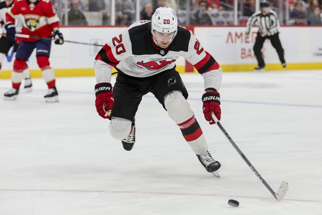 Jan 13, 2024; Sunrise, Florida, USA; New Jersey Devils center Michael McLeod (20) moves the puck against the Florida Panthers during the first period at Amerant Bank Arena. Mandatory Credit: Sam Navarro-USA TODAY Sports