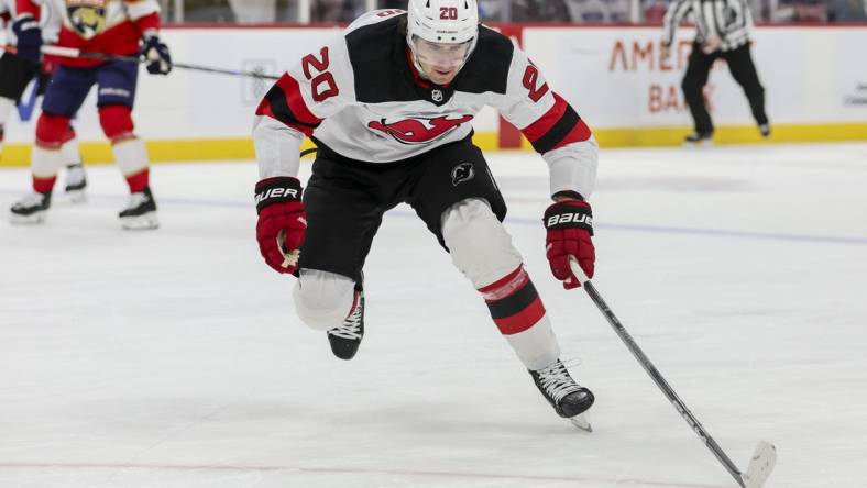 Jan 13, 2024; Sunrise, Florida, USA; New Jersey Devils center Michael McLeod (20) moves the puck against the Florida Panthers during the first period at Amerant Bank Arena. Mandatory Credit: Sam Navarro-USA TODAY Sports