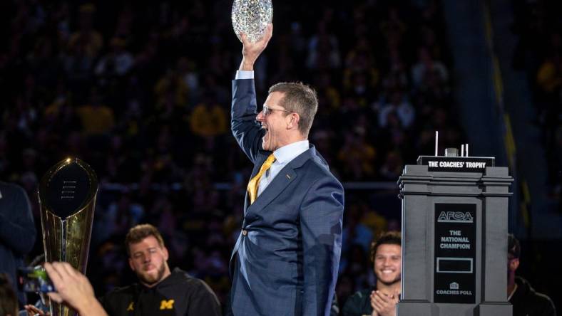 Michigan head coach Jim Harbaugh lifts the AFCA Coaches' Trophy during the national championship celebration at Crisler Center in Ann Arbor on Saturday, Jan. 13, 2024.