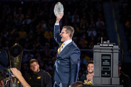 Michigan head coach Jim Harbaugh lifts the AFCA Coaches' Trophy during the national championship celebration at Crisler Center in Ann Arbor on Saturday, Jan. 13, 2024.