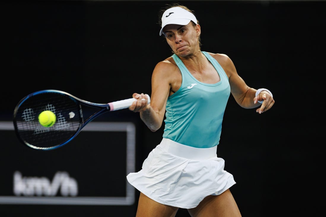 Jan 14, 2024; Melbourne, Victoria, Australia;  Magda Linette of Poland hits a shot against Caroline Wozniacki of Denmark in the first round of the women s singles.Mandatory Credit: Mike Frey-USA TODAY Sports