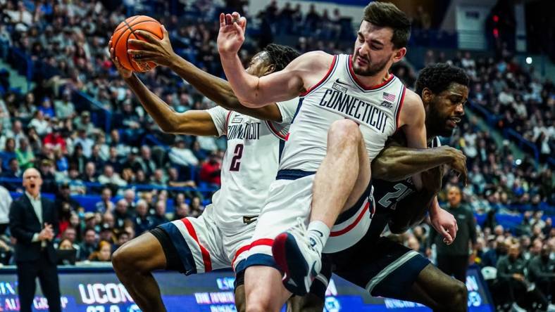 Jan 14, 2024; Hartford, Connecticut, USA; Georgetown Hoyas forward Supreme Cook (24) called for the foul against Connecticut Huskies forward Alex Karaban (11) in the first half at XL Center. Mandatory Credit: David Butler II-USA TODAY Sports