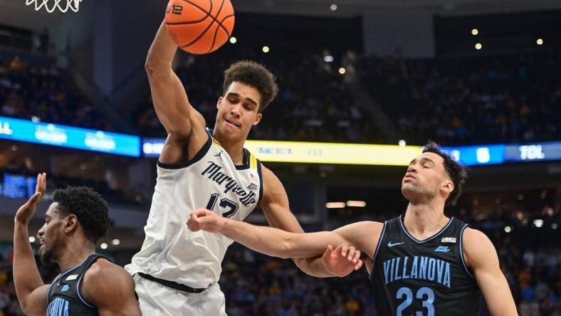 Jan 15, 2024; Milwaukee, Wisconsin, USA; Marquette Golden Eagles forward Oso Ighodaro (13) and Villanova Wildcats forward Tyler Burton (23) reach for a rebound in the second half at Fiserv Forum. Mandatory Credit: Benny Sieu-USA TODAY Sports