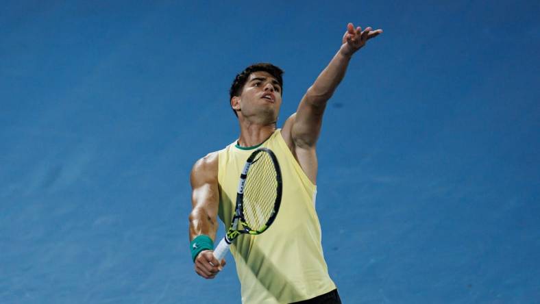 Jan 16, 2024; Melbourne, Victoria, Australia;   Carlos Alcaraz of Spain hits a shot against Richard Gasquet of France in the first round of the men s singles at the Australian Open. Mandatory Credit: Mike Frey-USA TODAY Sports