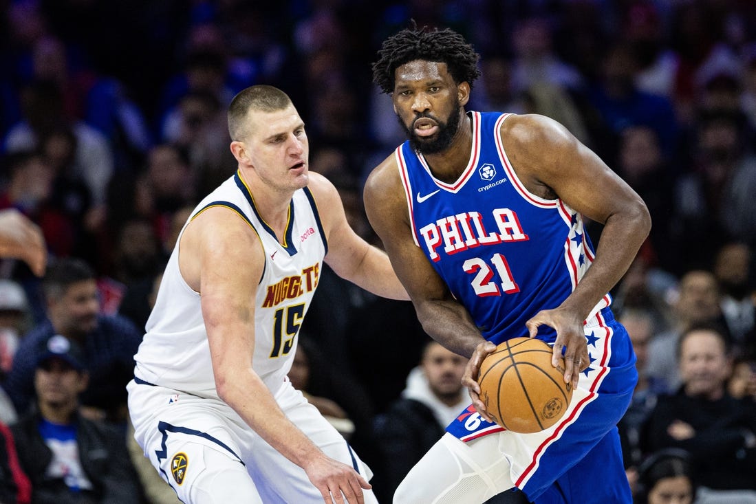 Jan 16, 2024; Philadelphia, Pennsylvania, USA; Philadelphia 76ers center Joel Embiid (21) controls the ball against Denver Nuggets center Nikola Jokic (15) during the first quarter at Wells Fargo Center. Mandatory Credit: Bill Streicher-USA TODAY Sports