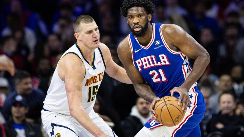 Jan 16, 2024; Philadelphia, Pennsylvania, USA; Philadelphia 76ers center Joel Embiid (21) controls the ball against Denver Nuggets center Nikola Jokic (15) during the first quarter at Wells Fargo Center. Mandatory Credit: Bill Streicher-USA TODAY Sports