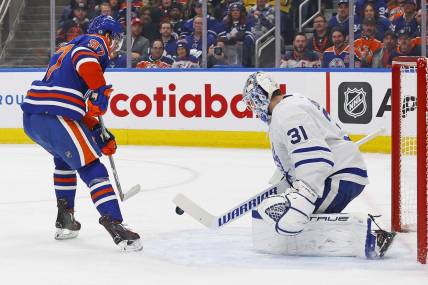 Jan 16, 2024; Edmonton, Alberta, CAN; Toronto Maple Leafs goaltender Martin Jones (31) makes a save on one Edmonton Oilers forward Connor McDavid (97) during the first period at Rogers Place. Mandatory Credit: Perry Nelson-USA TODAY Sports
