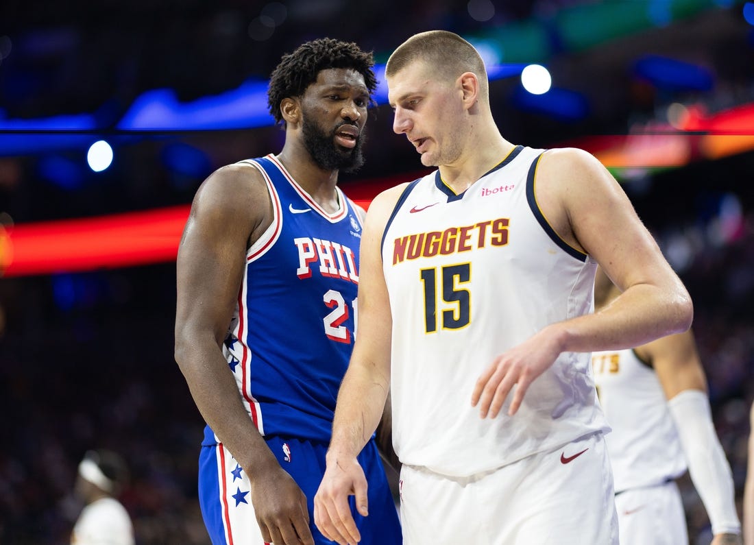 Jan 16, 2024; Philadelphia, Pennsylvania, USA; Philadelphia 76ers center Joel Embiid (21) glances at Denver Nuggets center Nikola Jokic (15) during a break in action in the third quarter at Wells Fargo Center. Mandatory Credit: Bill Streicher-USA TODAY Sports