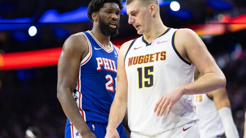 Jan 16, 2024; Philadelphia, Pennsylvania, USA; Philadelphia 76ers center Joel Embiid (21) glances at Denver Nuggets center Nikola Jokic (15) during a break in action in the third quarter at Wells Fargo Center. Mandatory Credit: Bill Streicher-USA TODAY Sports