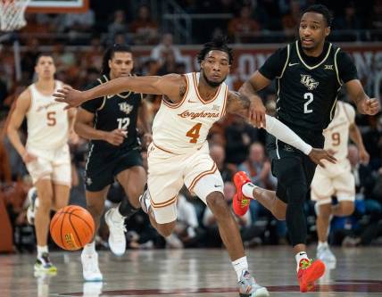 Texas Longhorns guard Tyrese Hunter (4) holds back UCF Knights guard Shemarri Allen (2) as they run after the ball during the game against University of Central Florida at the Moody center in Austin, Texas Wednesday, Jan. 17, 2023.
