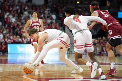 Jan 19, 2024; Madison, Wisconsin, USA; Wisconsin Badgers guard Max Klesmit (11) picks up a loose ball against Indiana Hoosiers forward Malik Reneau (5) and teammate Wisconsin Badgers guard Kamari McGee (4) during the first half at the Kohl Center. Mandatory Credit: Kayla Wolf-USA TODAY Sports