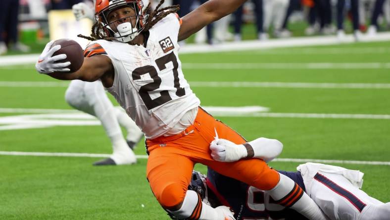 Jan 13, 2024; Houston, Texas, USA; Cleveland Browns running back Kareem Hunt (27) breaks the tackle of Houston Texans linebacker Christian Harris (48) as he scores a touchdown in a 2024 AFC wild card game at NRG Stadium. Mandatory Credit: Thomas Shea-USA TODAY Sports