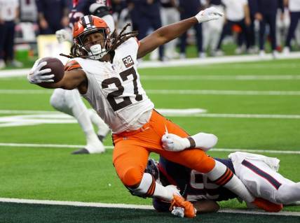 Jan 13, 2024; Houston, Texas, USA; Cleveland Browns running back Kareem Hunt (27) breaks the tackle of Houston Texans linebacker Christian Harris (48) as he scores a touchdown in a 2024 AFC wild card game at NRG Stadium. Mandatory Credit: Thomas Shea-USA TODAY Sports