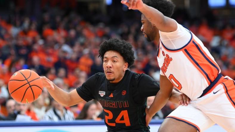 Jan 20, 2024; Syracuse, New York, USA; Miami (Fl) Hurricanes guard Nijel Pack (24) controls the ball as Syracuse Orange guard Kyle Cuffe Jr. (0) defends during the first half at the JMA Wireless Dome. Mandatory Credit: Rich Barnes-USA TODAY Sports