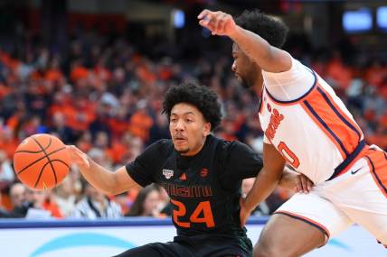 Jan 20, 2024; Syracuse, New York, USA; Miami (Fl) Hurricanes guard Nijel Pack (24) controls the ball as Syracuse Orange guard Kyle Cuffe Jr. (0) defends during the first half at the JMA Wireless Dome. Mandatory Credit: Rich Barnes-USA TODAY Sports