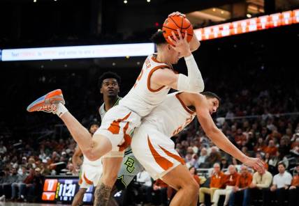 Texas Longhorns guard Chendall Weaver (2) lands on top of forward Kadin Shedrick (5) after catching a defensive rebound in the first half of the Longhorns   game against the Baylor Bears at the Moody Center in Austin, Jan 20, 2024.