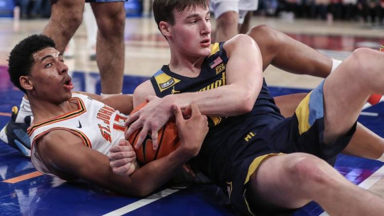 Jan 20, 2024; New York, New York, USA;  St. John's Red Storm guard RJ Luis Jr. (12) and Marquette Golden Eagles guard Tyler Kolek (11) fight for a loose ball in the second half at Madison Square Garden. Mandatory Credit: Wendell Cruz-USA TODAY Sports