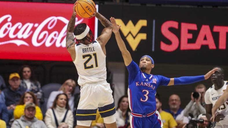 Jan 20, 2024; Morgantown, West Virginia, USA; West Virginia Mountaineers guard RaeQuan Battle (21) shoots over Kansas Jayhawks guard Dajuan Harris Jr. (3) during the first half at WVU Coliseum. Mandatory Credit: Ben Queen-USA TODAY Sports