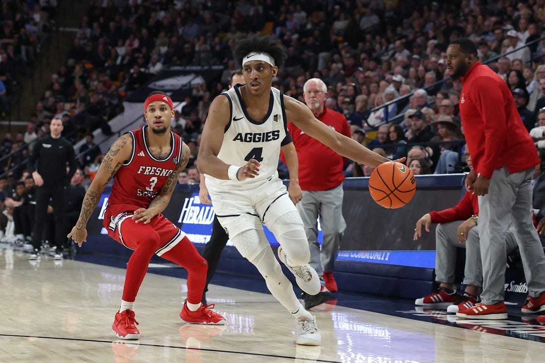 Jan 20, 2024; Logan, Utah, USA; Utah State Aggies guard Ian Martinez (4) drives past Fresno State Bulldogs guard Isaiah Hill (3) during the first half at Dee Glen Smith Spectrum. Mandatory Credit: Rob Gray-USA TODAY Sports