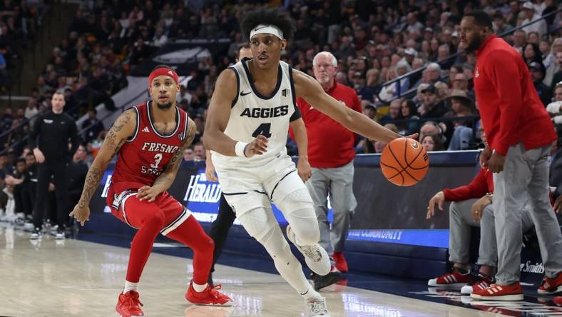 Jan 20, 2024; Logan, Utah, USA; Utah State Aggies guard Ian Martinez (4) drives past Fresno State Bulldogs guard Isaiah Hill (3) during the first half at Dee Glen Smith Spectrum. Mandatory Credit: Rob Gray-USA TODAY Sports