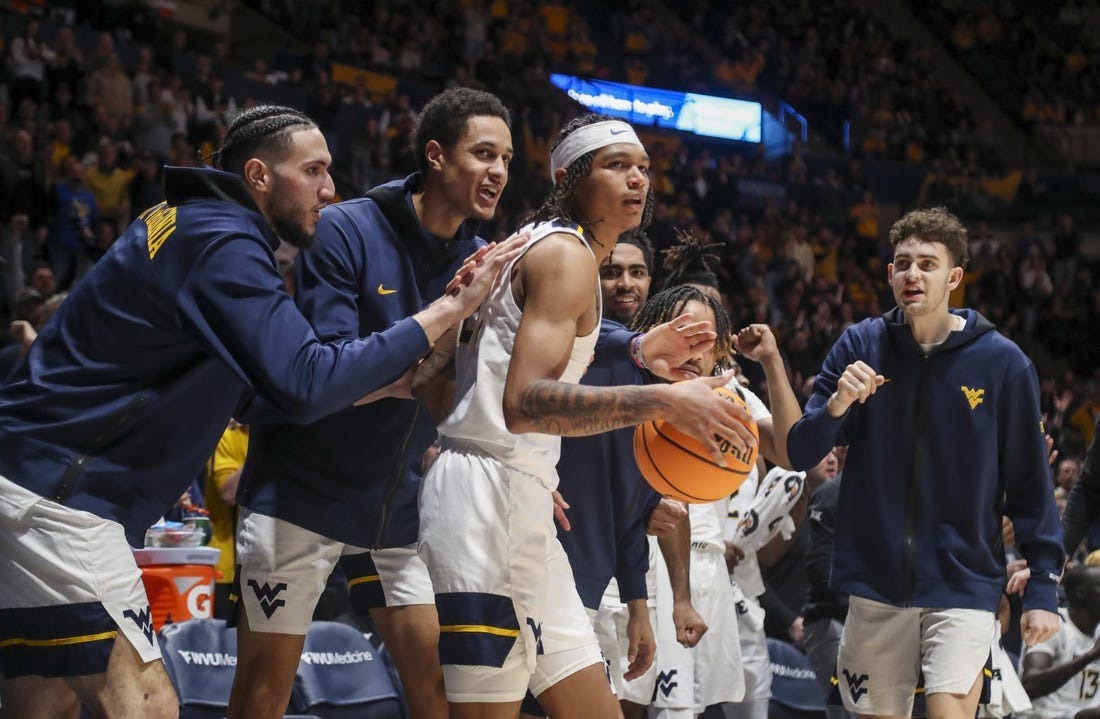 Jan 20, 2024; Morgantown, West Virginia, USA; West Virginia Mountaineers guard RaeQuan Battle (21) is greeted by teammates after a play during the second half against the Kansas Jayhawks at WVU Coliseum. Mandatory Credit: Ben Queen-USA TODAY Sports