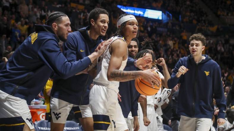 Jan 20, 2024; Morgantown, West Virginia, USA; West Virginia Mountaineers guard RaeQuan Battle (21) is greeted by teammates after a play during the second half against the Kansas Jayhawks at WVU Coliseum. Mandatory Credit: Ben Queen-USA TODAY Sports