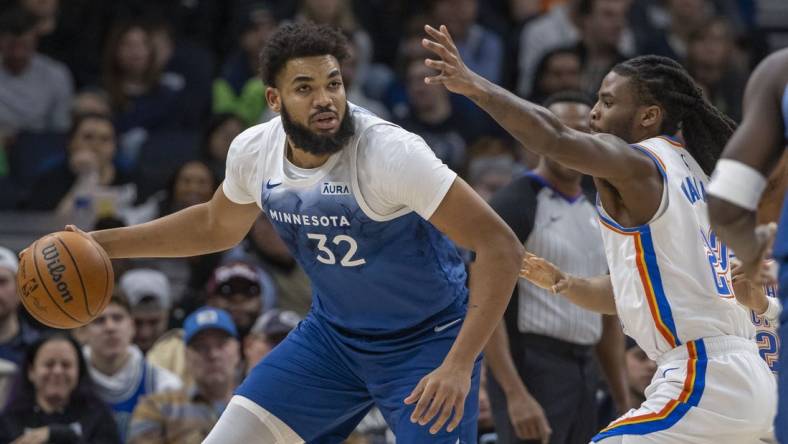 Jan 20, 2024; Minneapolis, Minnesota, USA; Minnesota Timberwolves center Karl-Anthony Towns (32) dribbles the ball and looks to pass Oklahoma City Thunder guard Cason Wallace (22) plays defense in the first half at Target Center. Mandatory Credit: Jesse Johnson-USA TODAY Sports