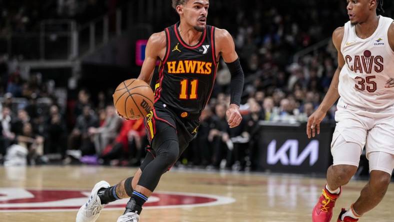 Jan 20, 2024; Atlanta, Georgia, USA; Atlanta Hawks guard Trae Young (11) dribbles against Cleveland Cavaliers forward Isaac Okoro (35) during the second half at State Farm Arena. Mandatory Credit: Dale Zanine-USA TODAY Sports