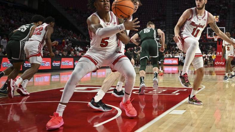 Jan 21, 2024; College Park, Maryland, USA;  Maryland Terrapins guard DeShawn Harris-Smith (5) reaches for a loose ball during the first half against the Michigan State Spartans at Xfinity Center. Mandatory Credit: Tommy Gilligan-USA TODAY Sports