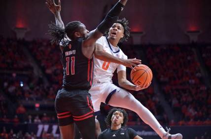 Jan 21, 2024; Champaign, Illinois, USA; Illinois Fighting Illini guard Terrence Shannon Jr. (0) drives to the basket as Rutgers Scarlet Knights center Clifford Omoruyi (11) defends during the first half at State Farm Center. Mandatory Credit: Ron Johnson-USA TODAY Sports