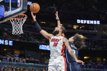 Jan 21, 2024; Orlando, Florida, USA; Miami Heat forward Caleb Martin (16) goes to the basket against Orlando Magic guard Anthony Black (0) during the second quarter at Amway Center. Mandatory Credit: Mike Watters-USA TODAY Sports