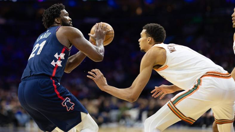 Jan 22, 2024; Philadelphia, Pennsylvania, USA; Philadelphia 76ers center Joel Embiid (21) shoots against San Antonio Spurs center Victor Wembanyama (1) during the second quarter at Wells Fargo Center. Mandatory Credit: Bill Streicher-USA TODAY Sports