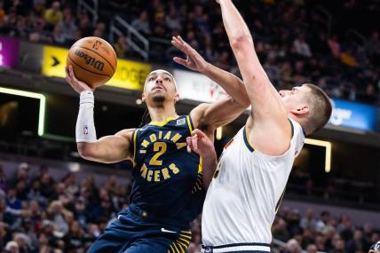 Jan 23, 2024; Indianapolis, Indiana, USA; Indiana Pacers guard Andrew Nembhard (2) shoots the ball while Denver Nuggets center Nikola Jokic (15) defends in the first half at Gainbridge Fieldhouse. Mandatory Credit: Trevor Ruszkowski-USA TODAY Sports