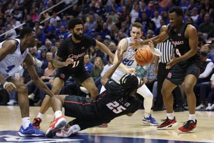Jan 23, 2024; Provo, Utah, USA; Houston Cougars forward Joseph Tugler (25) passes the ball to guard L.J. Cryer (4) defended by Brigham Young Cougars guard Spencer Johnson (20) during the second half at Marriott Center. Mandatory Credit: Rob Gray-USA TODAY Sports