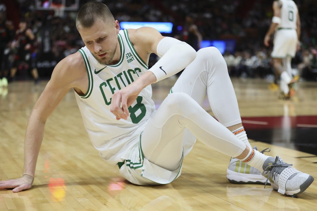 Jan 25, 2024; Miami, Florida, USA; Boston Celtics center Kristaps Porzingis (8) reacts on the floor after a play against the Miami Heat during the third quarter at Kaseya Center. Mandatory Credit: Sam Navarro-USA TODAY Sports